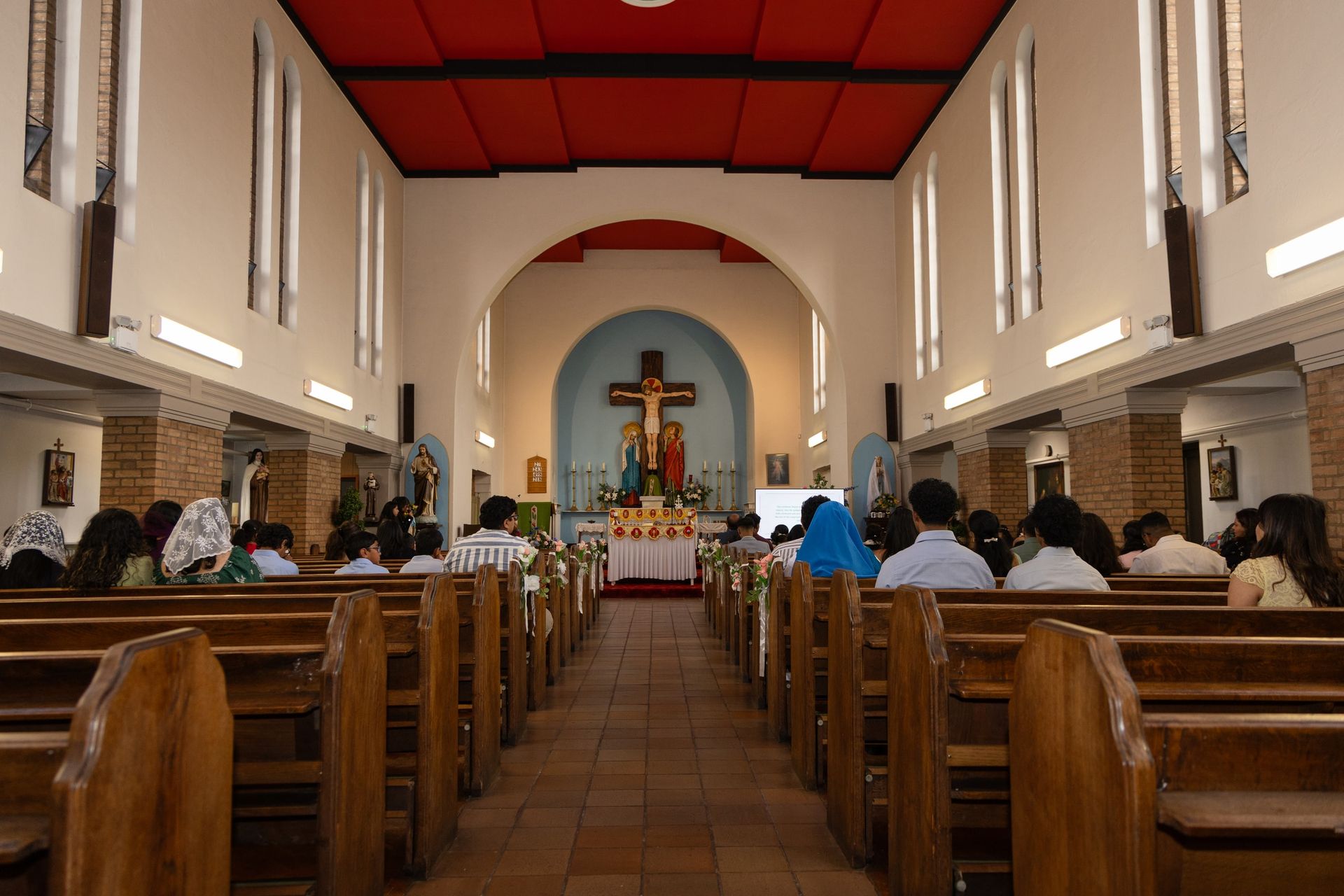 Guests seated in wooden pews facing the altar during a church ceremony