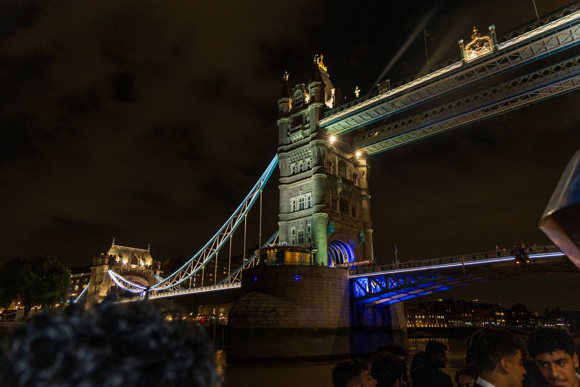 Tower Bridge illuminated at night, photographed from a boat on the River Thames